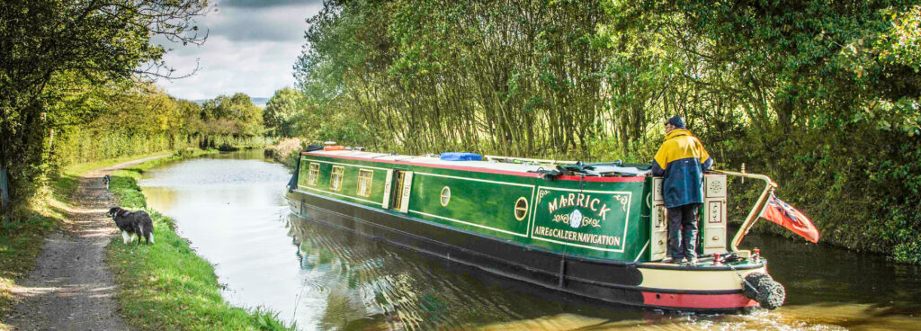 A traditional narrow long boat cruising the Macclesfield Canal, Cheshire Ring Canals, Cheshire, UK