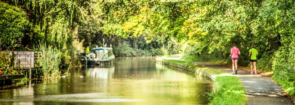 Joggers on the Peaks Canal towpath, Cheshire Ring Canals, Cheshire, UK