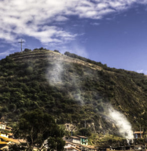 Smoke rises above Cusco to the sacred site of the Inca citadel, Cusco, Peru