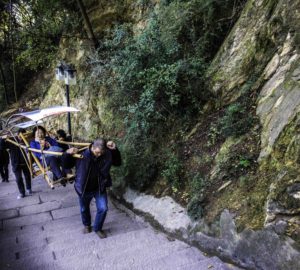 Porters carrying paying passengers to the top of BaidiCheng stairs, White Emperor City, Yangtze River Three Gorges Cruise, Chongqing, China