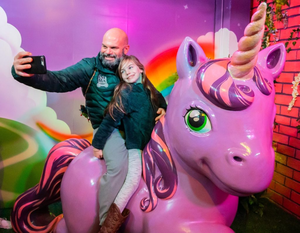 Visitors ride the unicorn, Selfieville, Golden State Theater, Monterey, California