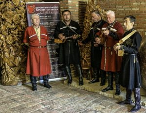 Men in traditional Georgian attire, playing in a winery, T'bilisi, Republic of Georgia