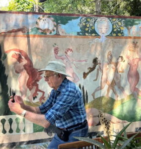 The author near a whimsical bacchanalian mural at Les Clos du Peyronnet