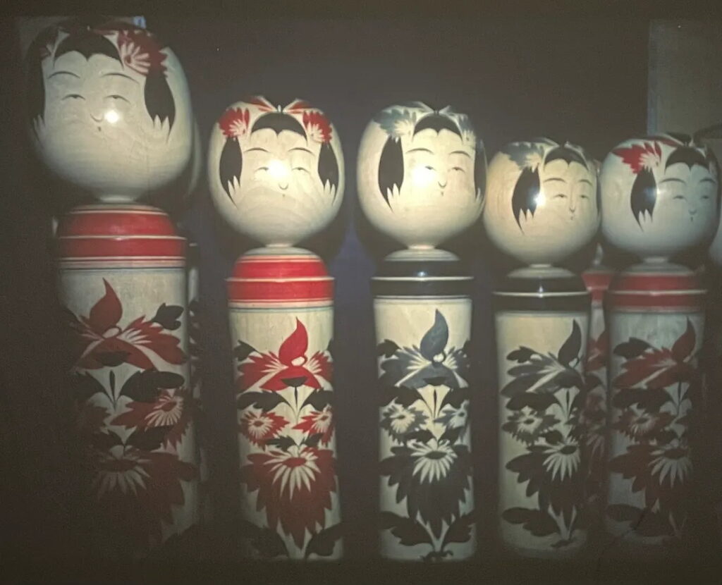 Narugo kokeshi with their distinctive chrysanthemum design in red and grey, Tohoku, Honshu, Japan.